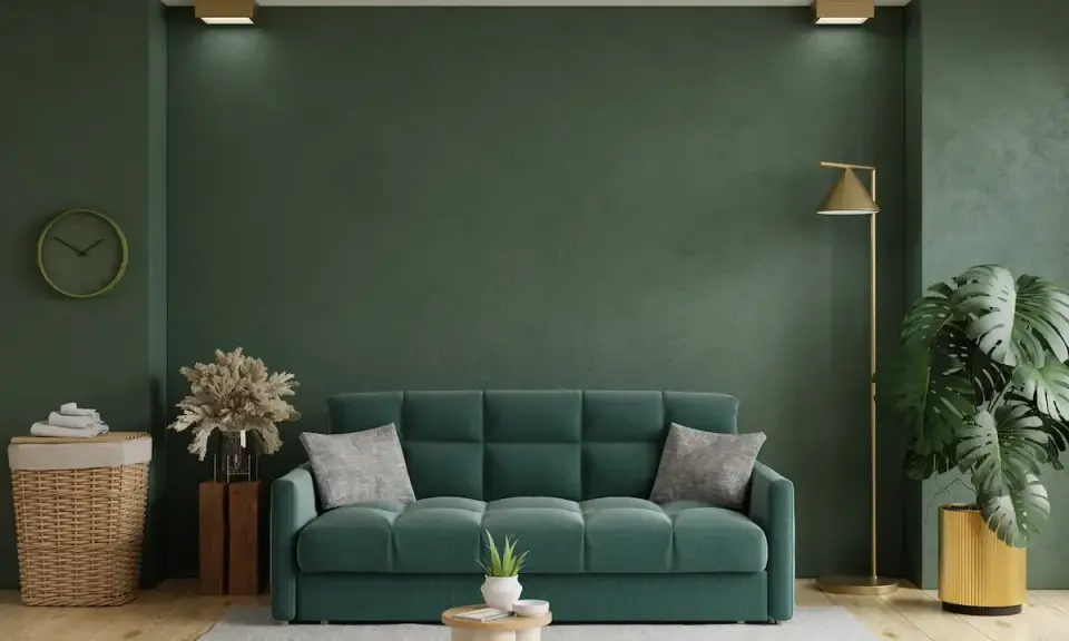 Un acogedor salón con un sofá verde, plantas y una lámpara dorada.