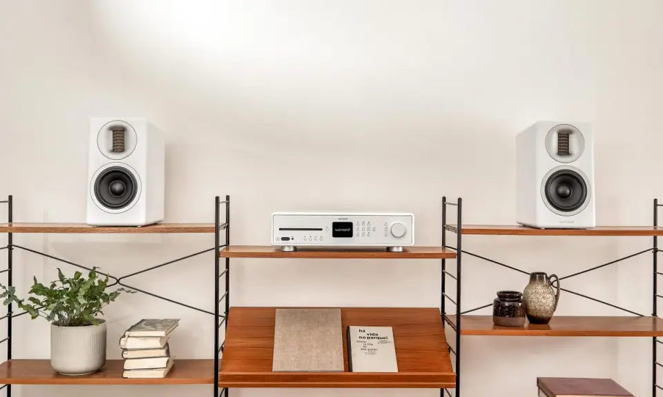 Élégant système audio blanc avec deux enceintes hifi et un lecteur CD sur des étagères en bois.