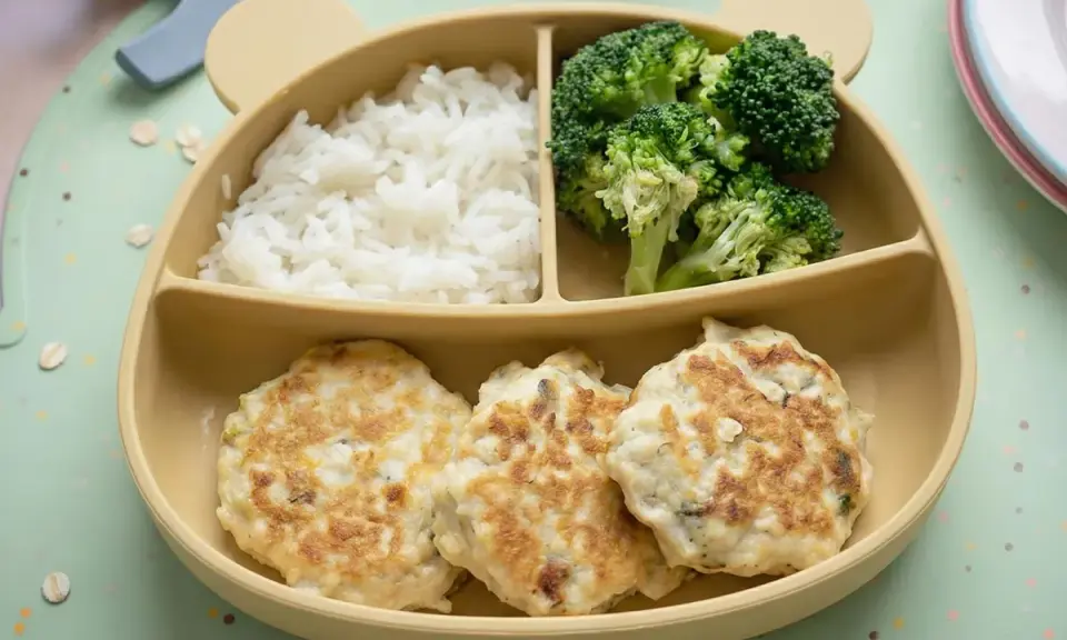 Deliciosas hamburguesas de pollo caseras para niños, acompañadas de arroz blanco y brócoli, servidas en un plato con forma de oso.