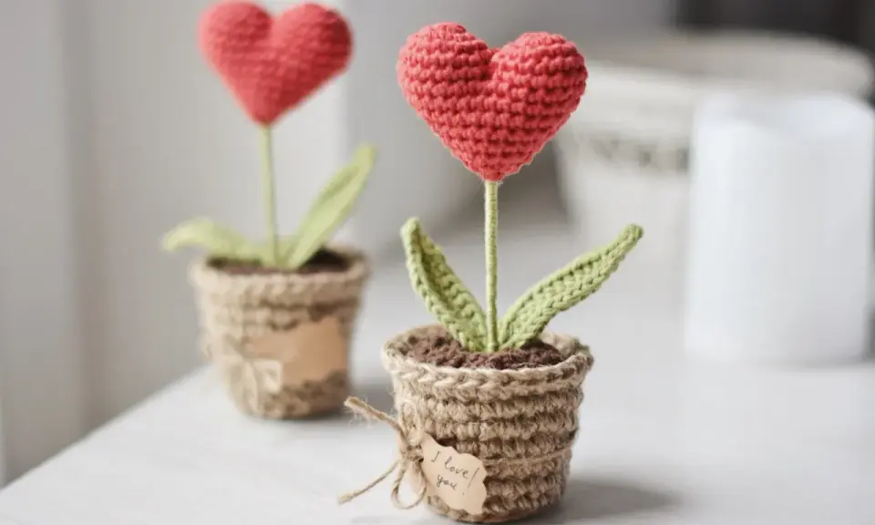 Dos tiernos corazones amigurumi en macetas de yute, uno con una etiqueta que dice "I love you".