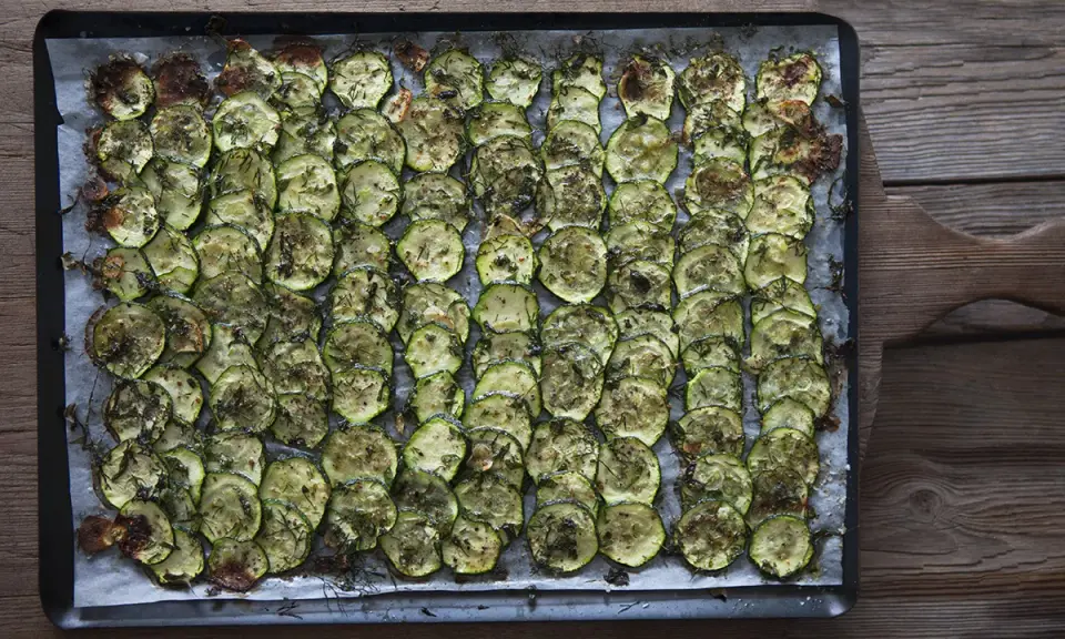 En plåt med ugnsbakad zucchini, skivad och kryddad med örter. Perfekt som tillbehör till middagen.