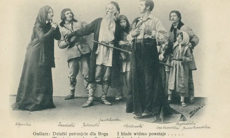 Grupa postaci w strojach ludowych, w tym starszy mężczyzna z brodą, młodzi ludzie i dzieci.