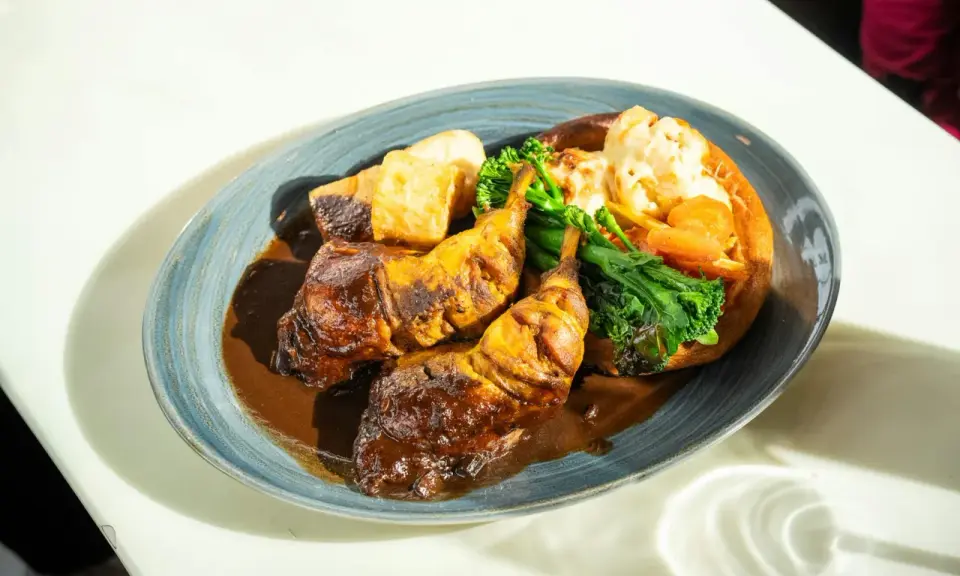Pyszny niedzielny obiad: pieczone udka kurczaka w sosie, pieczone ziemniaki, brokuły i kalafior zapiekany w Yorkshire pudding.