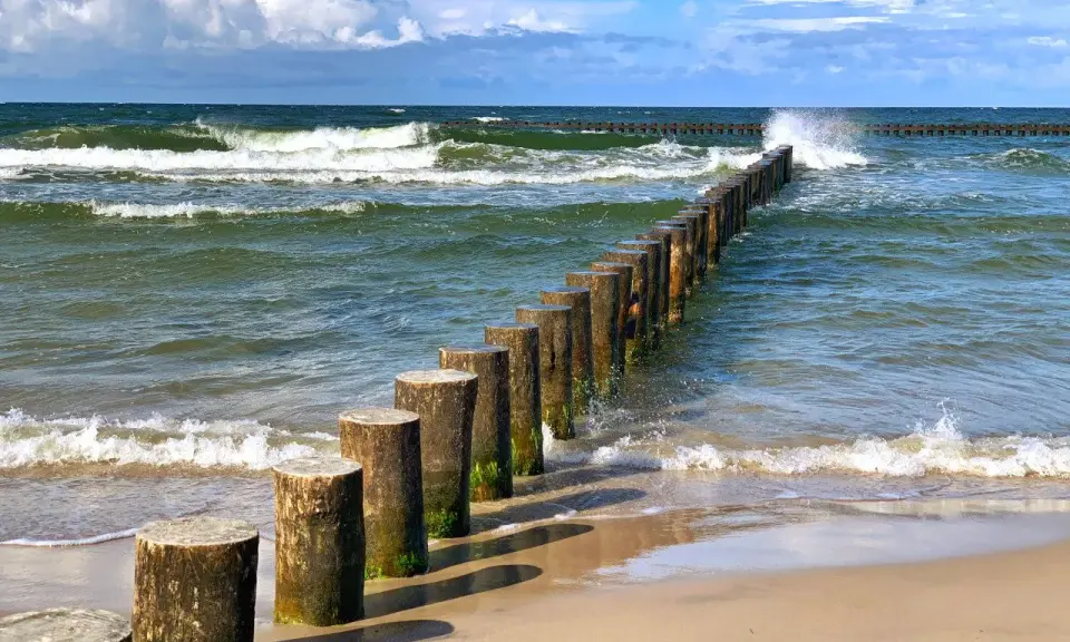 Jastrzębia Góra co zobaczyć: falochrony na plaży i wzburzone morze. Idealne miejsce na spacer i podziwianie Bałtyku.