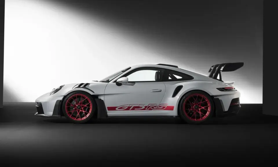 Weißer Porsche GT3 RS mit roten Felgen und Schriftzug. Ein Sportwagen, der Leistung und Eleganz vereint.