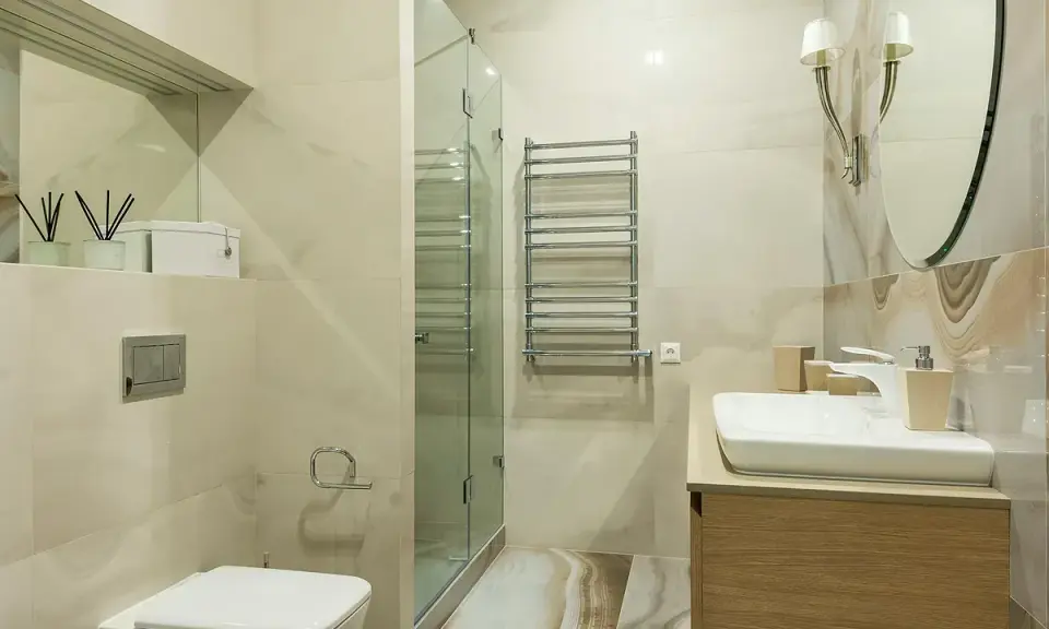 Baño moderno con ducha de cristal, lavabo y WC. Ideal para instalar extractor baño y mantener el ambiente fresco.