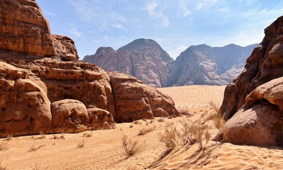 Pustynia w Jordanii, Wadi Rum. Piaskowe wydmy i skalne formacje pod błękitnym niebem.