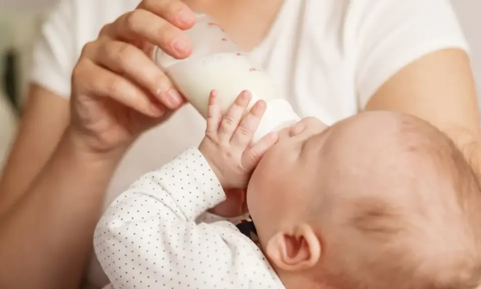 Dziecko pije mleko modyfikowane z butelki. Karmienie to może mieć różne konsekwencje dla rozwoju malucha.