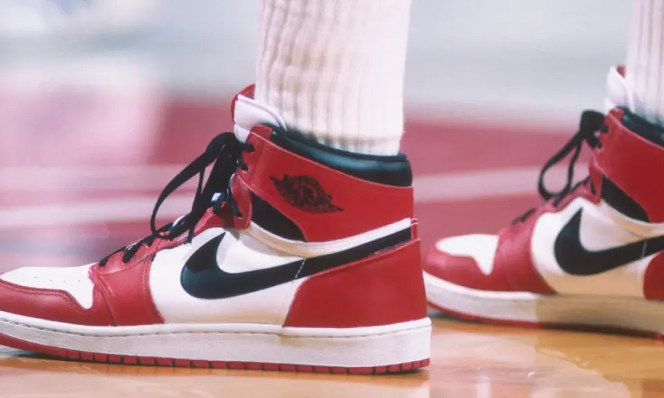 Die ersten Jordan Schuhe, rot-weiß-schwarz, auf einem Basketballfeld. Ein ikonischer Sneaker-Moment.
