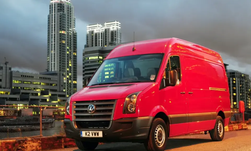 Czerwony Volkswagen Crafter 2.5 TDI na tle nocnego miasta.