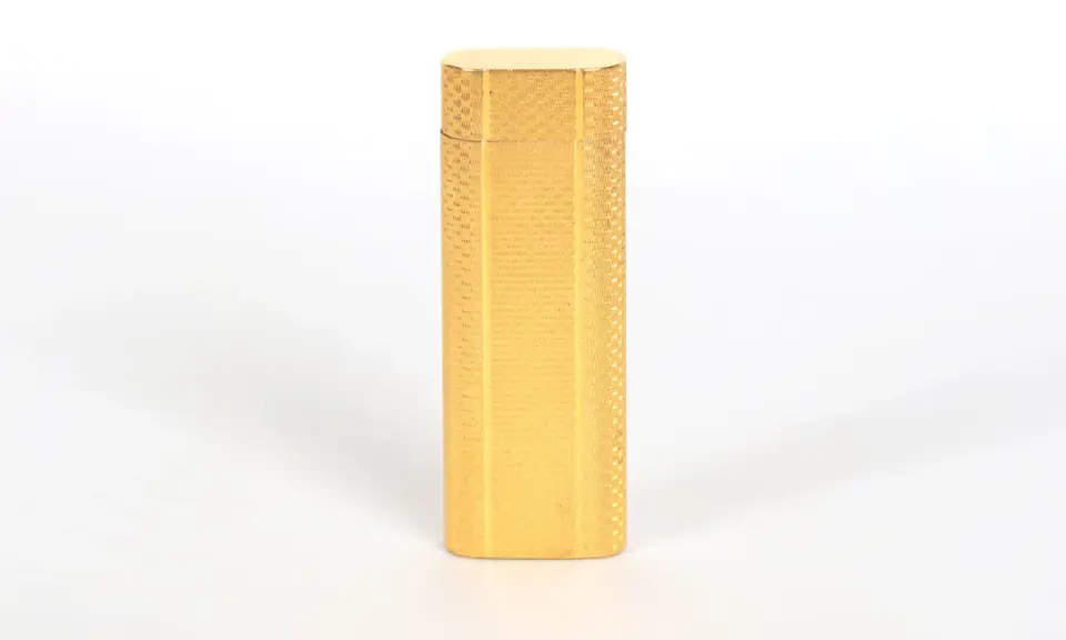 Briquet Cartier doré, finement guilloché. Une pièce de collection dont l'estimation est en cours.