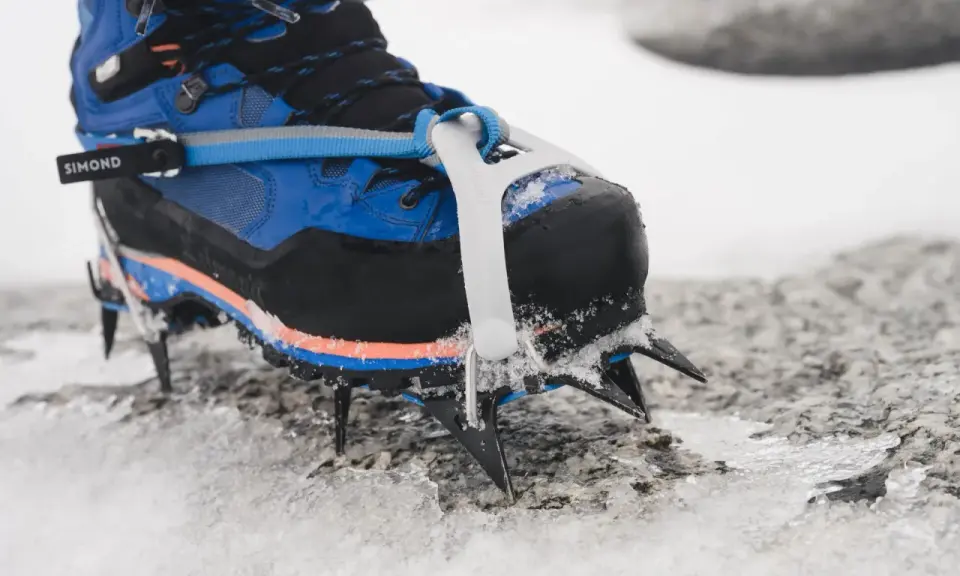 Buty do raków koszykowych Simond z ostrymi zębami wbijają się w lód i śnieg, zapewniając pewność na górskim szlaku.