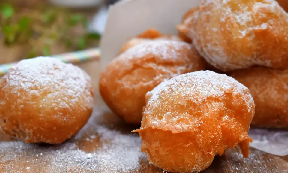 Des pets de none dorés et saupoudrés de sucre glace, prêts à être dégustés. Un délice croustillant et moelleux.