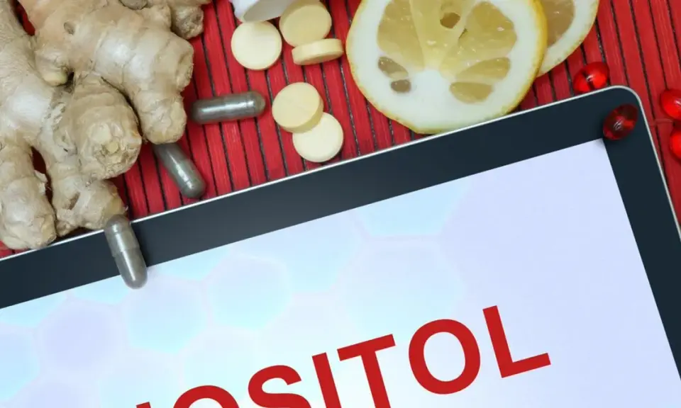 Tablet z napisem "INOZYTOL CO TO". Obok imbir, plasterki cytryny, kapsułki i tabletki.
