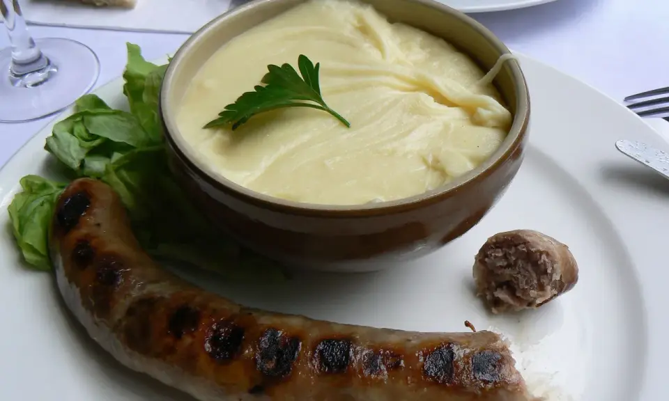 Saucisse grillée et purée onctueuse, un plat traditionnel auvergnat réconfortant.