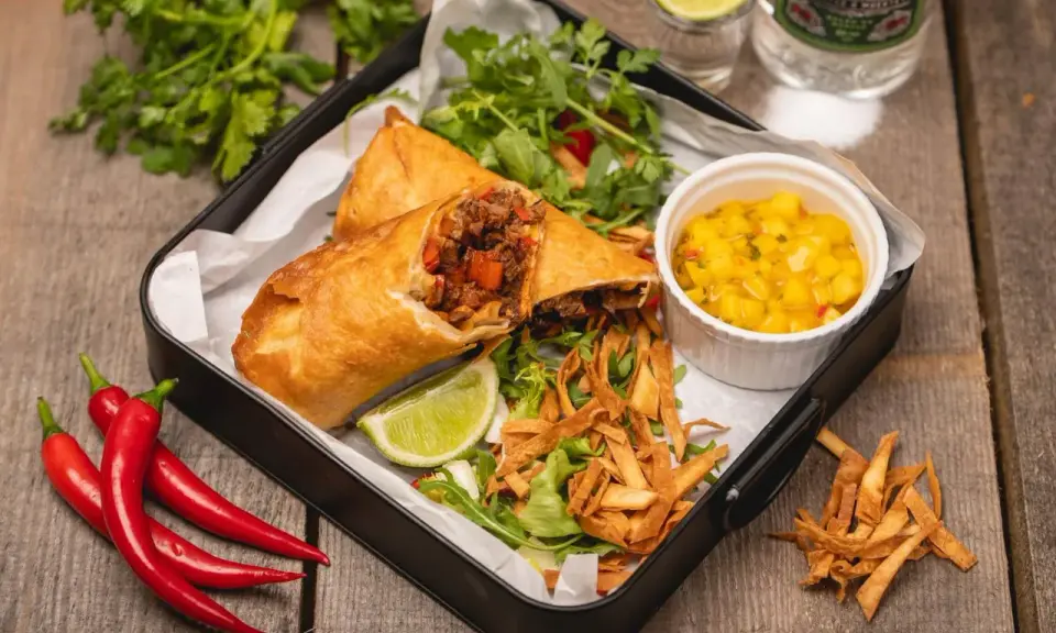 Chrupiące rolki z nadzieniem mięsnym i warzywnym, podane z salsą mango, sałatką i limonką. Prawdziwy smak tex mex!