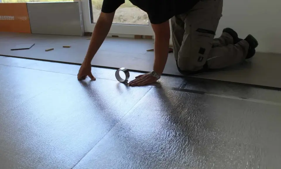Instalando la mejor base aislante para suelo laminado. Se coloca una lámina plateada reflectante, asegurando un aislamiento térmico y acústico óptimo.