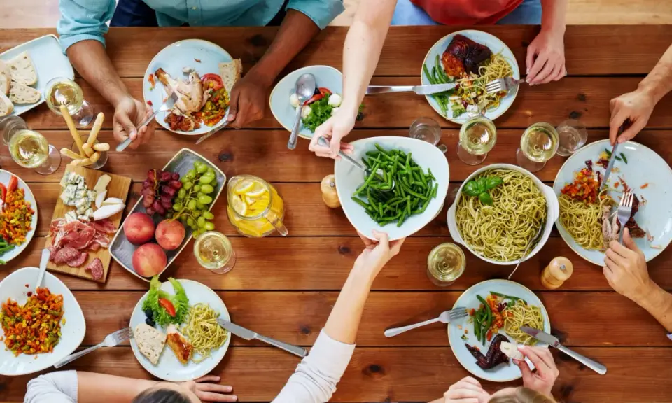 Un repas convivial entre collègues : pâtes, poulet rôti, salade, fruits et charcuterie. Une belle idée repas entre collègues travail.