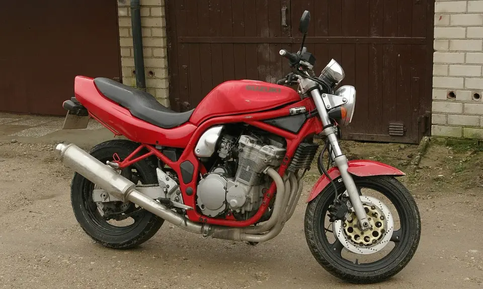 Czerwony Suzuki Bandit 600, gotowy do jazdy, z widocznym silnikiem i wydechem.