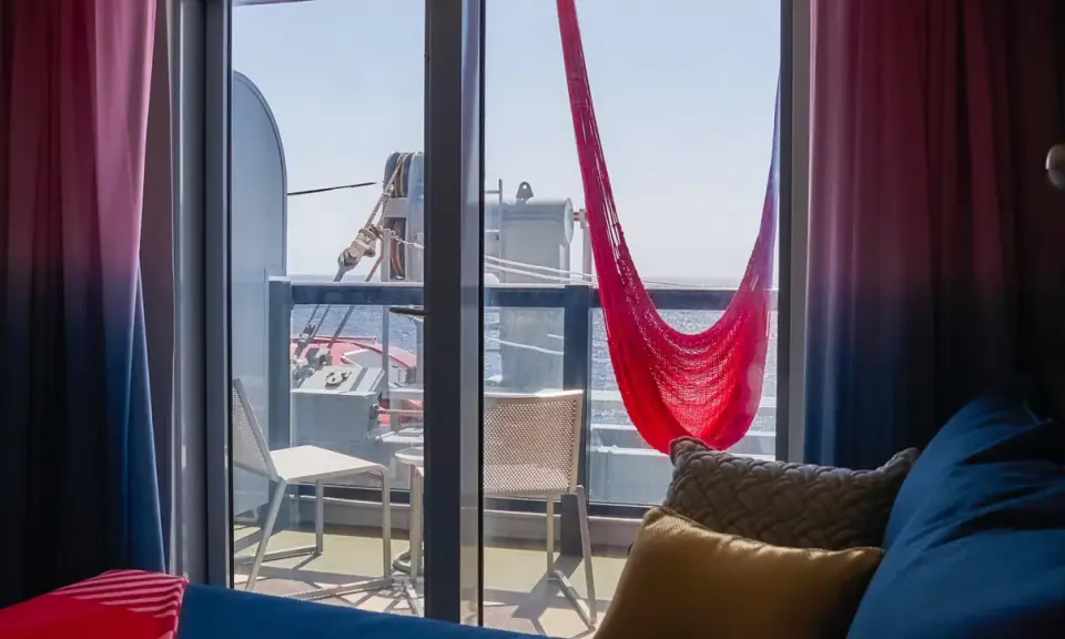 Cabina balcone vista parziale MSC con amaca rossa e cuscini accoglienti.