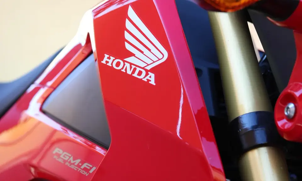 Czerwony motocykl Honda z logo i napisem PGM-FI. Pamiętaj o regularnych przeglądach motocykla 125!