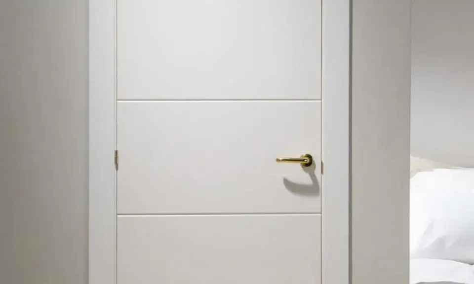 Puerta lacada en blanco con tirador dorado. Aprende como limpiar puertas lacadas en blanco para mantenerlas impecables.