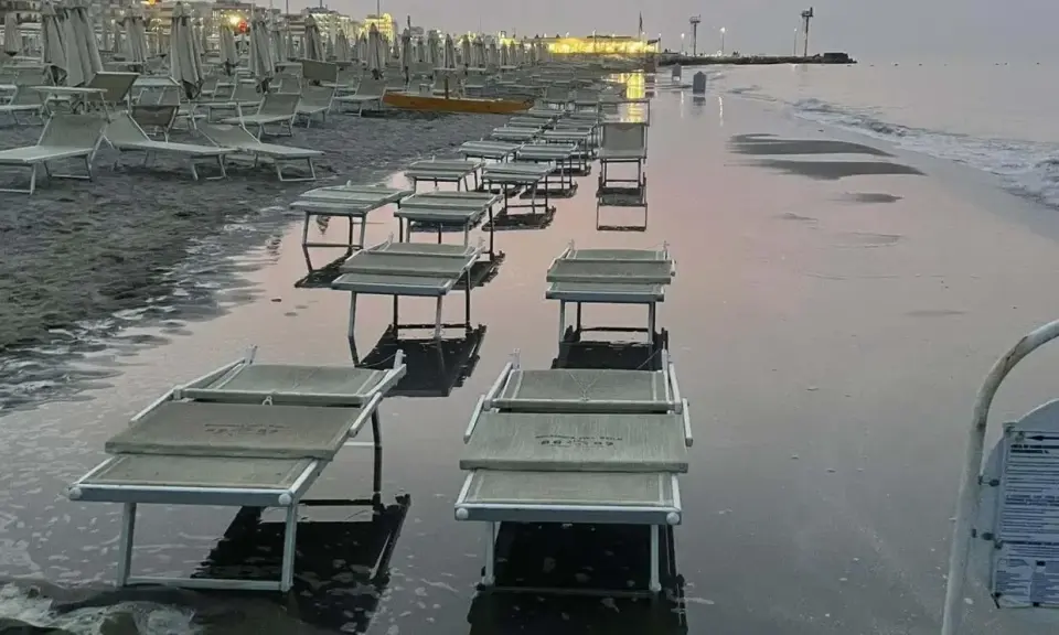 Lettini da spiaggia sommersi dall'acqua a Riccione, con la bassa marea che ha lasciato il segno.