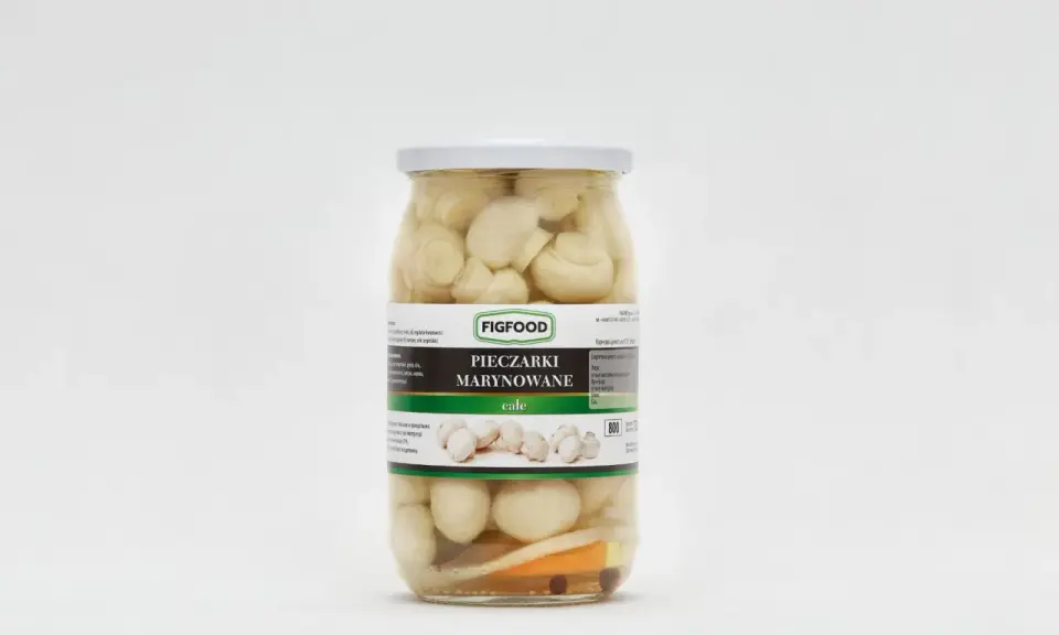 Słoik z marynowanymi pieczarkami marki Figfood, z widocznymi kawałkami warzyw na dnie.