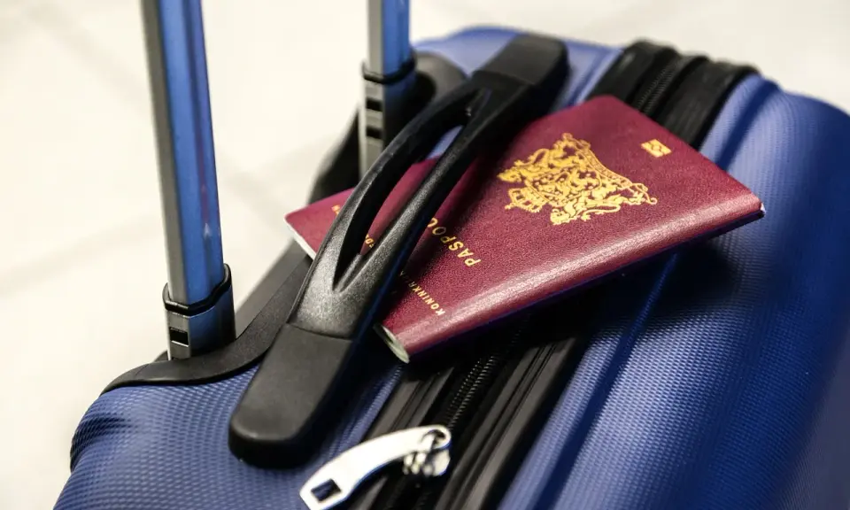 Bagaż rejestrowany Pegasus Airlines gotowy do podróży. Paszporty leżą na niebieskiej walizce, czekając na odprawę.
