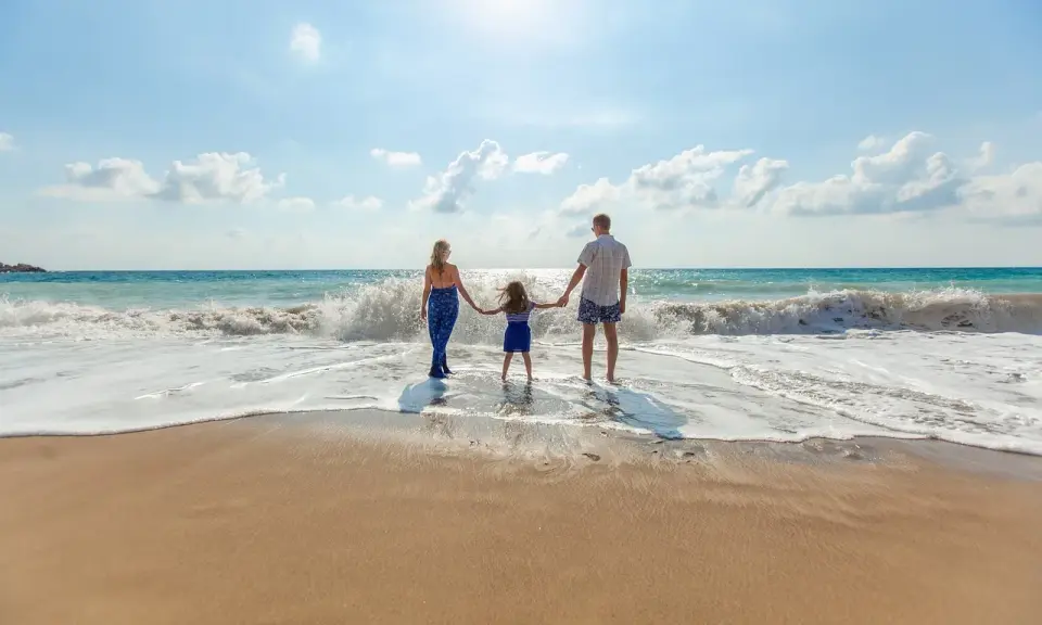 Famiglia felice sulla riviera romagnola con bambini, godendosi le onde del mare.