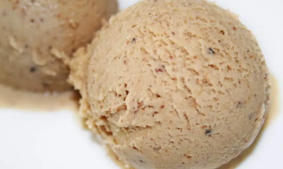 Deux boules de glace praliné, une recette gourmande et onctueuse, parsemée de petits éclats croquants.