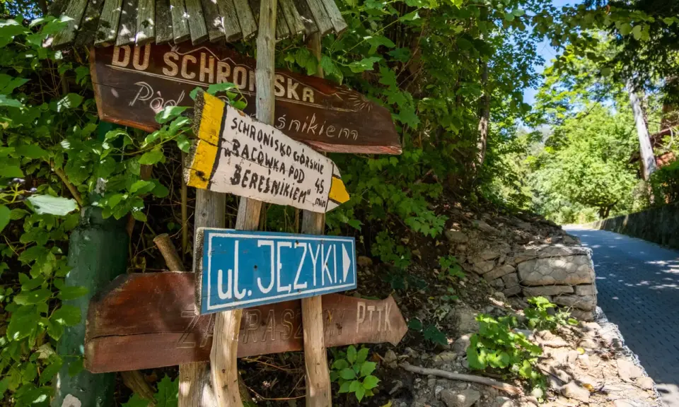 Drewniane drogowskazy wskazują drogę do schroniska górskiego Bacówka pod Beresnikiem. Sprawdź cennik i wybierz szlak!