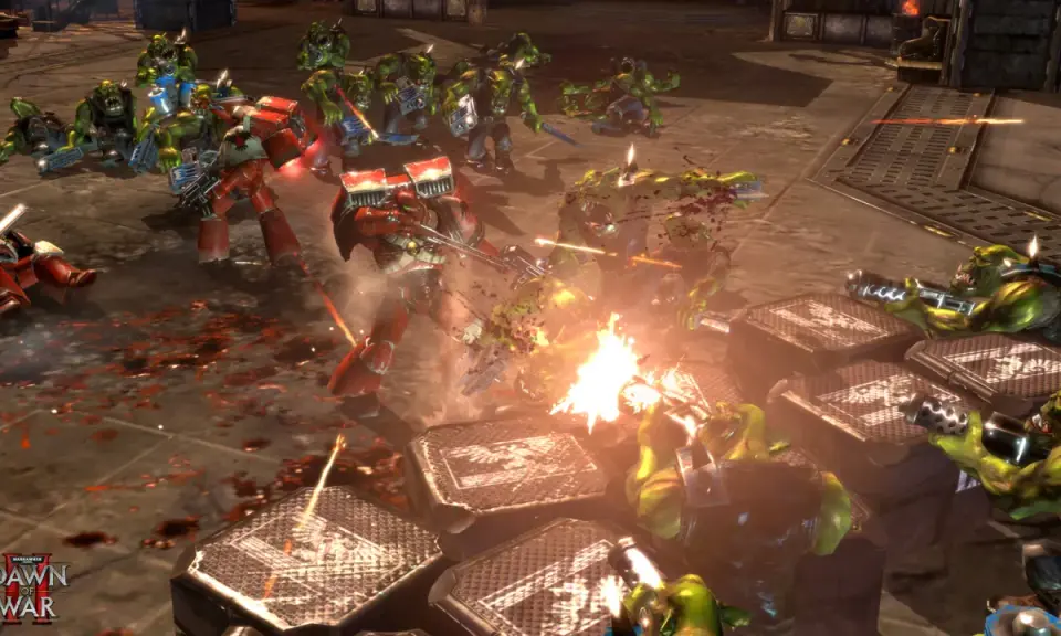 Intensywna bitwa w Dawn of War 2: Kosmiczni Marines walczą z Orkami. Krwawa jatka na polu bitwy.