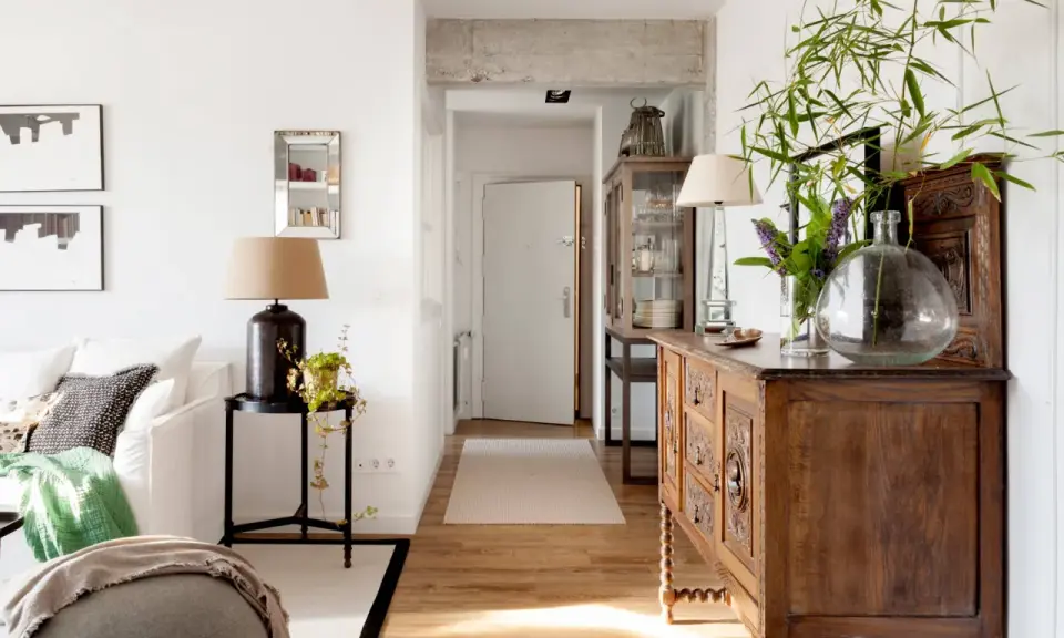 Un mueble oscuro puede alegrar una habitación con luz natural y plantas.