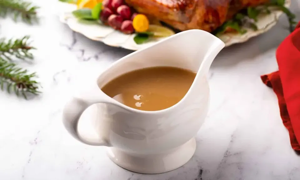 Saucière en porcelaine remplie d'une sauce pour dinde succulente, prête à accompagner le festin de Noël.