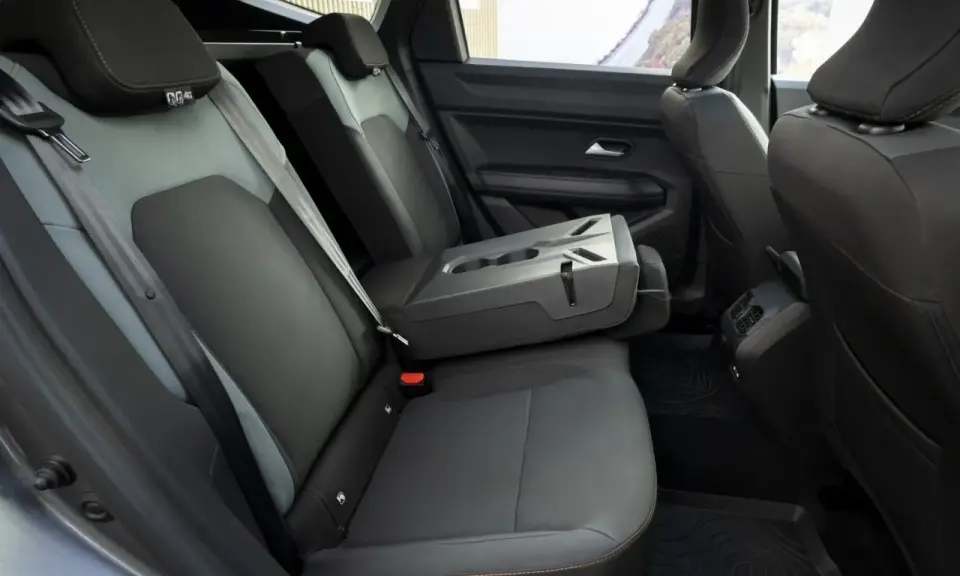 Interni Dacia Bigster: sedili posteriori in tessuto grigio e nero, bracciolo centrale ribaltabile con portabicchieri.