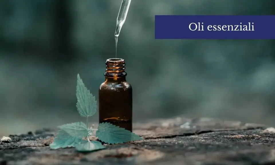 Una goccia di olio essenziale cade da un contagocce in una bottiglia ambrata, accanto a una foglia verde. Scopri come usare gli oli essenziali sulla pelle per un benessere naturale.
