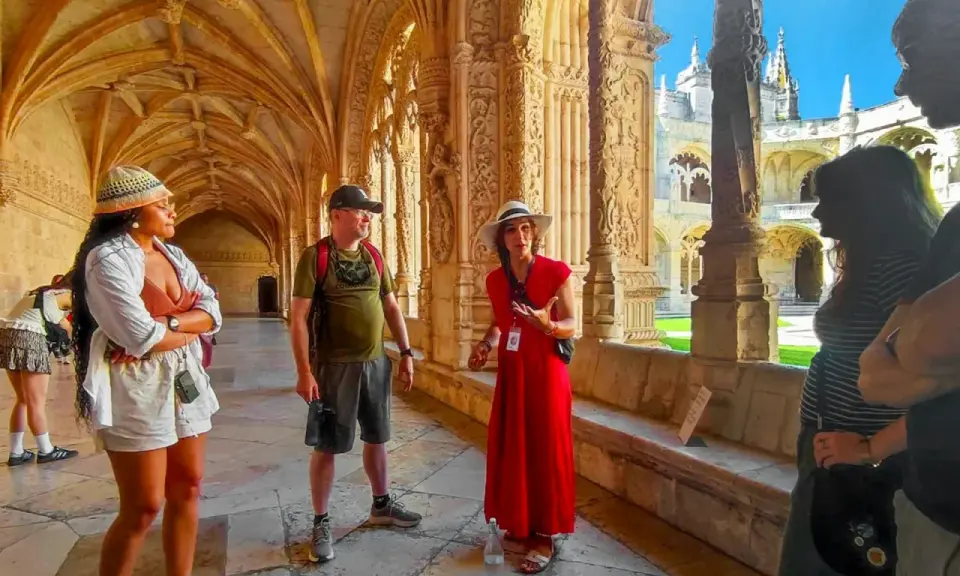 Besucher lauschen einer Führerin im Jeronimos Kloster. Die Architektur ist detailreich und beeindruckend.