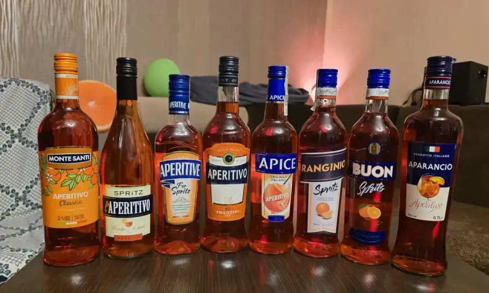Rząd butelek z pomarańczowym, lekkim alkoholem, idealnym na letnie wieczory. Wśród nich Monte Santi, Aperitivo, Apice, Ranginino, Buon Spritz i Aparancio.
