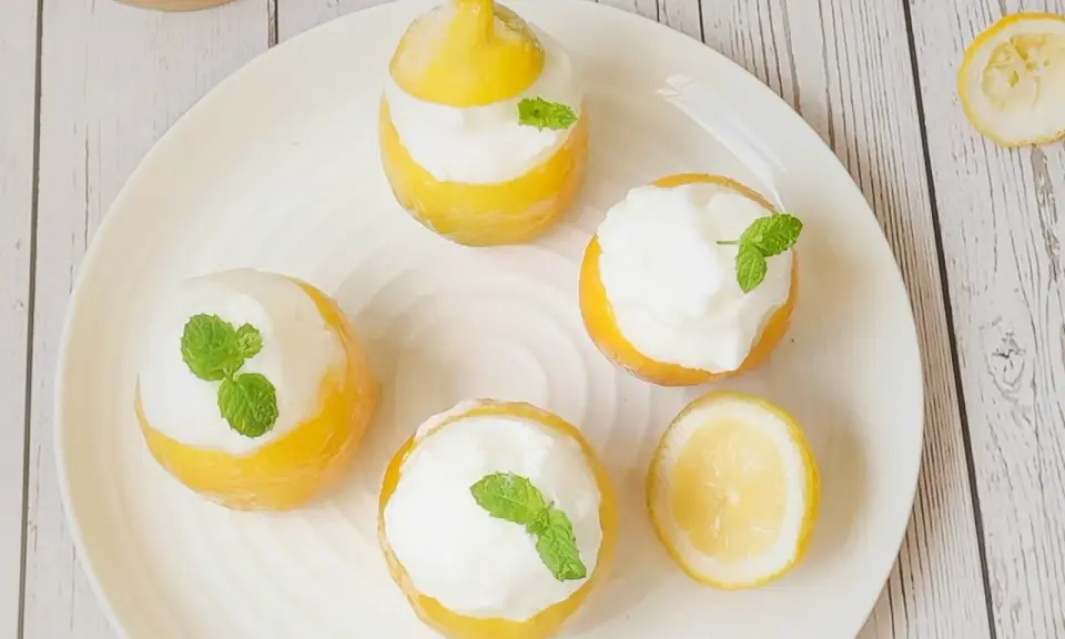 Délicieux citron givré, des citrons évidés remplis de sorbet et décorés de menthe fraîche. Un dessert rafraîchissant et visuellement attrayant.