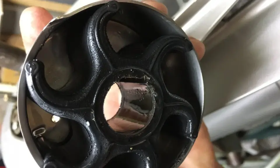 Pissette moteur hors bord Suzuki, pièce en caoutchouc usée, prête pour le remplacement.