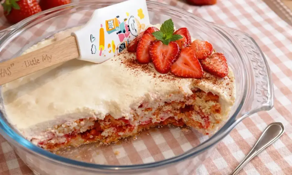 Un délicieux tiramisu fraise, garni de fruits frais et d'une touche de cacao, prêt à être dégusté.