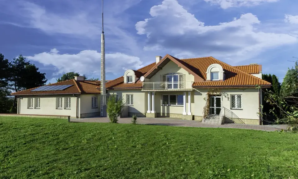 Nowy początek w ośrodku terapii uzależnień i depresji. Dom z czerwonym dachem, otoczony zielenią, zaprasza do spokoju i regeneracji.