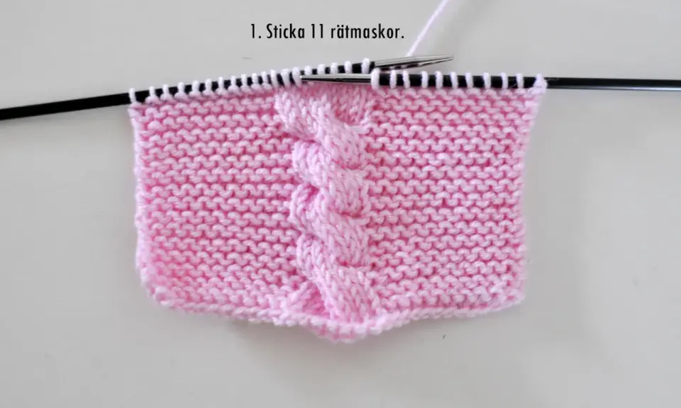 Rosa stickat tyg med flätmönster, perfekt för att sticka en disktrasa i land.
