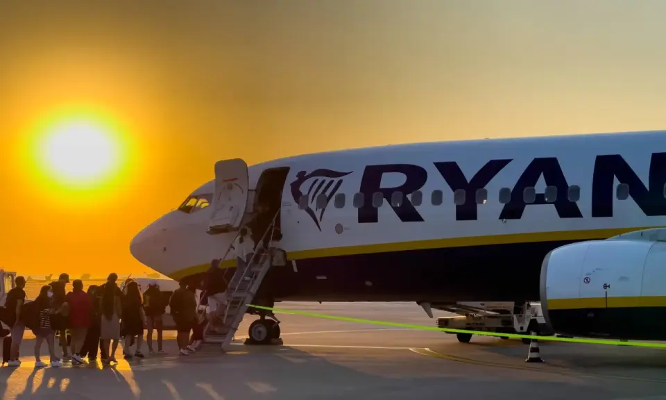 Zachód słońca nad lotniskiem, pasażerowie wsiadają do samolotu Ryanair. Wspaniałe **Ryanair loty z Bydgoszczy** czekają!