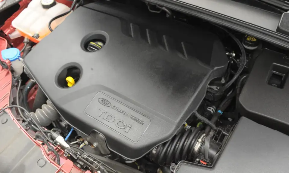 Silnik Ford Focus MK3 1.6 TDCI. Widoczna czarna osłona silnika z napisem "Ford Duratorq TDCI".