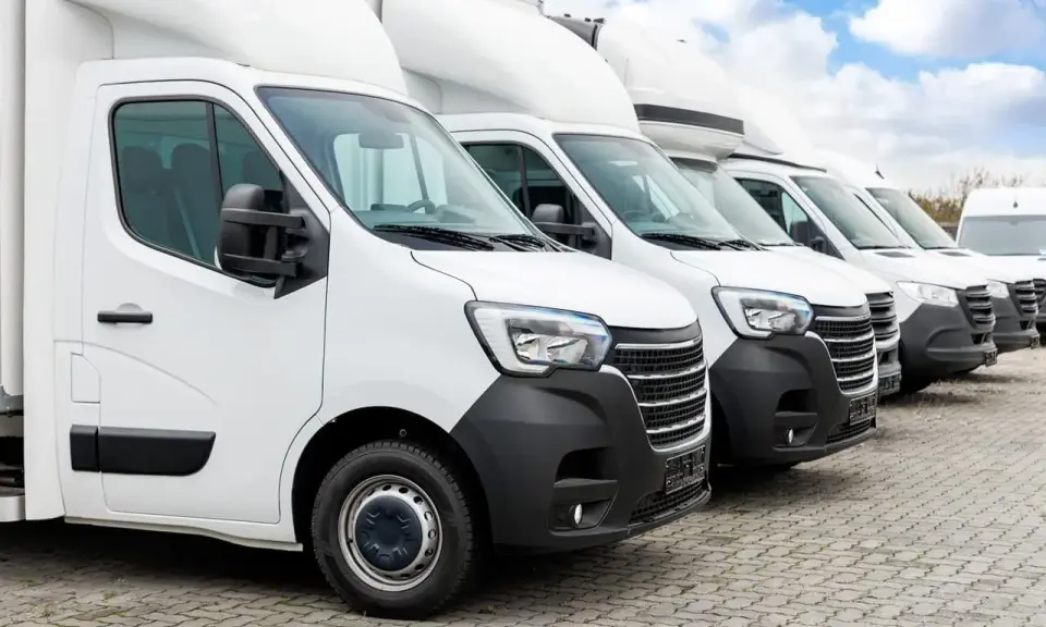 Fila de furgonetas blancas listas para la entrega. El modelo dgt n1 es el primero de la fila, con un diseño moderno y robusto.