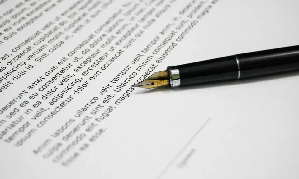 Una penna stilografica su un documento, che ricorda una esempio domanda di trasferimento motivata.