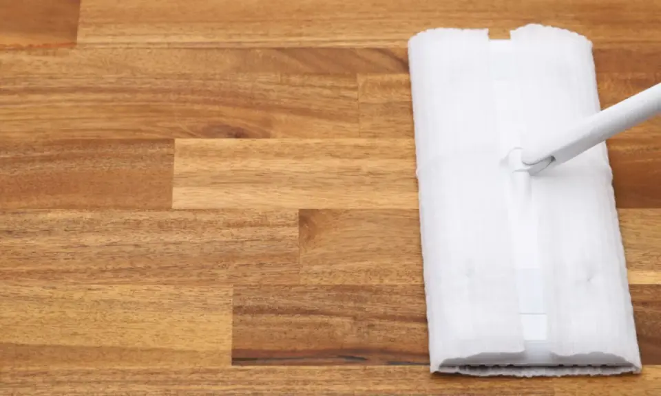 Un paño blanco se desliza sobre un suelo de madera, listo para limpiar.