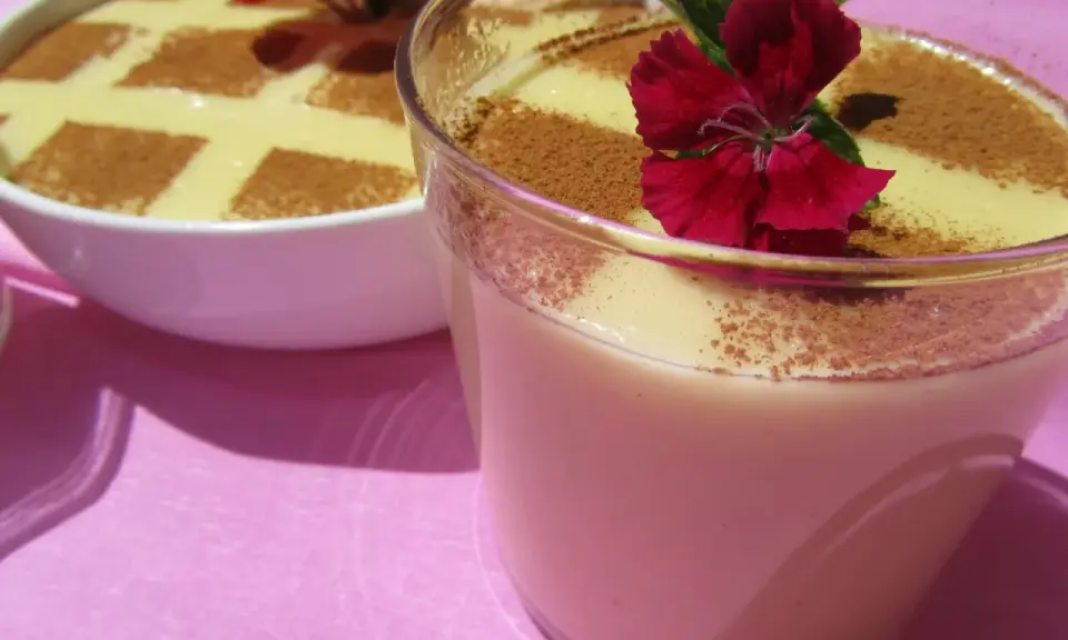 Deliciosas natillas Thermomix, espolvoreadas con canela y decoradas con flores rojas. ¡Un postre casero perfecto!